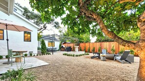 A backyard with a patio, outdoor seating, a grill, and a pergola. - Private In-Town Retreat (St Helena)