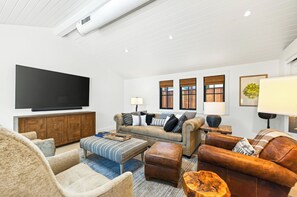 A modern living room with a flat-screen TV, a sofa set, a coffee table, and a fireplace. - Private In-Town Retreat (St Helena)
