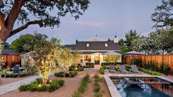 Ein Wohnhaus mit Schwimmbad, Außenbereich und einem gepflegten Garten.