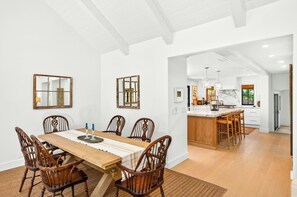 A spacious dining area with a wooden table and chairs, a kitchen with a marble countertop, and a modern ceiling design. - Private In-Town Retreat (St Helena)