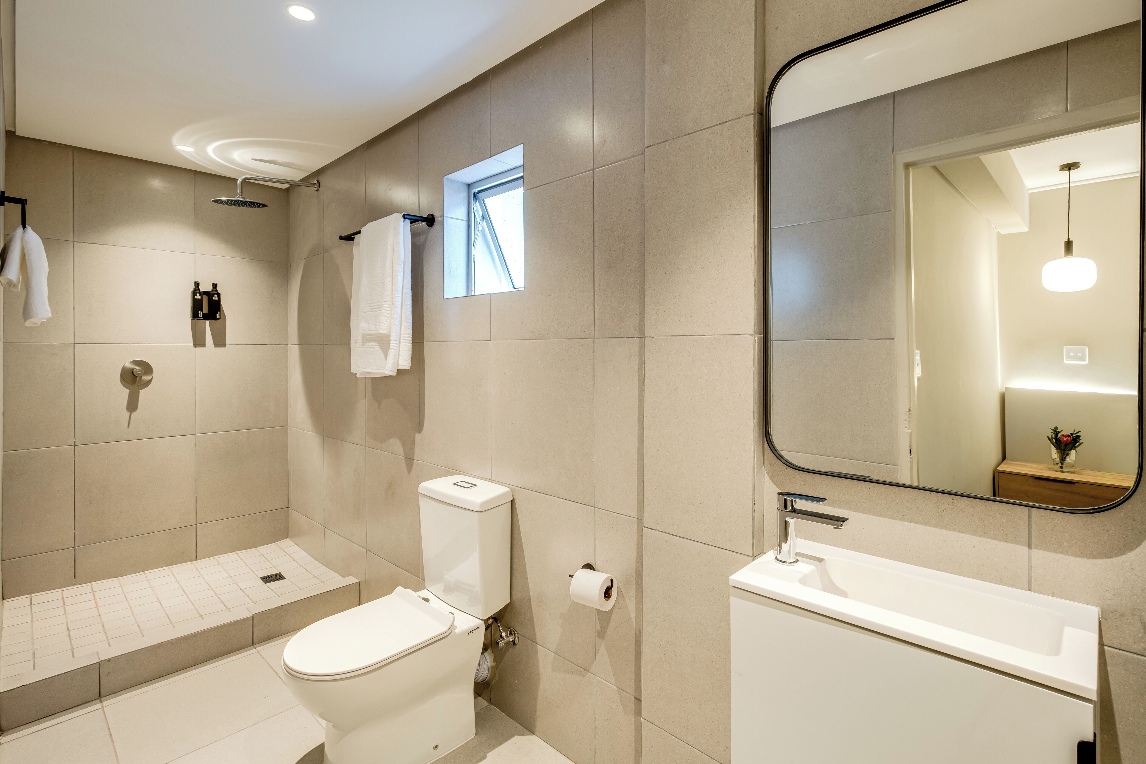 Un baño moderno con inodoro, bidé y lavamanos.