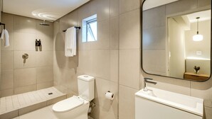 Un baño moderno con inodoro, bidé y lavamanos.