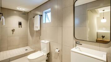 Un baño moderno con inodoro, bidé y lavamanos.