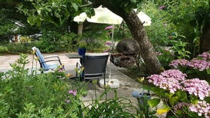 Un espace extérieur aménagé avec une table, des chaises et des parasols.