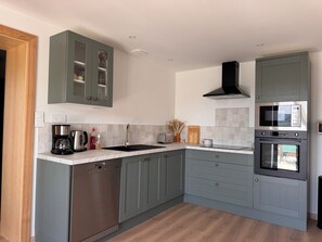A modern kitchen with grey cabinetry, a stainless steel dishwasher, a built-in oven, and a microwave. - House for 6 people Saint-Nabord (Saint-Nabord)