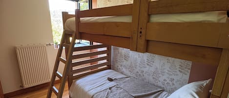 Ein Etagenbett mit einer Stehle, ein flauschiger weißer Teppich und eine Heizung.