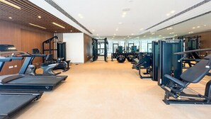 Academia com esteiras, aparelhos de musculação e pesos livres.