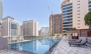 A rooftop swimming pool with a view of surrounding high-rise buildings, some under construction. - Vogue | VYB at Business Bay close to Downtown (Dubai)