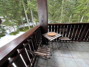 A wooden deck with a table and chairs, overlooking a forested area. - Triglav NP Apartment - above Bled (Zgornje Gorje)