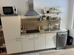 Una cocina moderna con microondas, estufa, fregadero y lavavajillas.