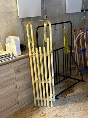 Una habitación con un armario de madera, un electrodoméstico blanco y una reja metálica.