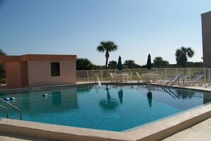 A swimming pool with lounge chairs and a palm tree in the background. - Holiday home with 2 bedrooms (St. Augustine)