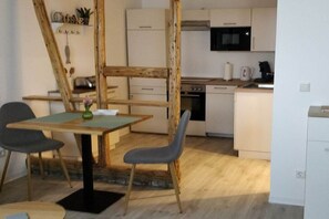 A compact kitchen with white cabinets, a microwave, and a coffee maker. - Holiday apartment with 1 bedroom (Bad Neuenahr-Ahrweiler)