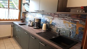 A kitchen with a black sink, a coffee maker, and a toaster. - Holiday apartment with 1 bedroom (Bayerisch Eisenstein)