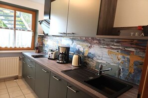 Eine Küche mit einem schwarzen Spülbecken, einer Kaffeemaschine und einem Toaster.