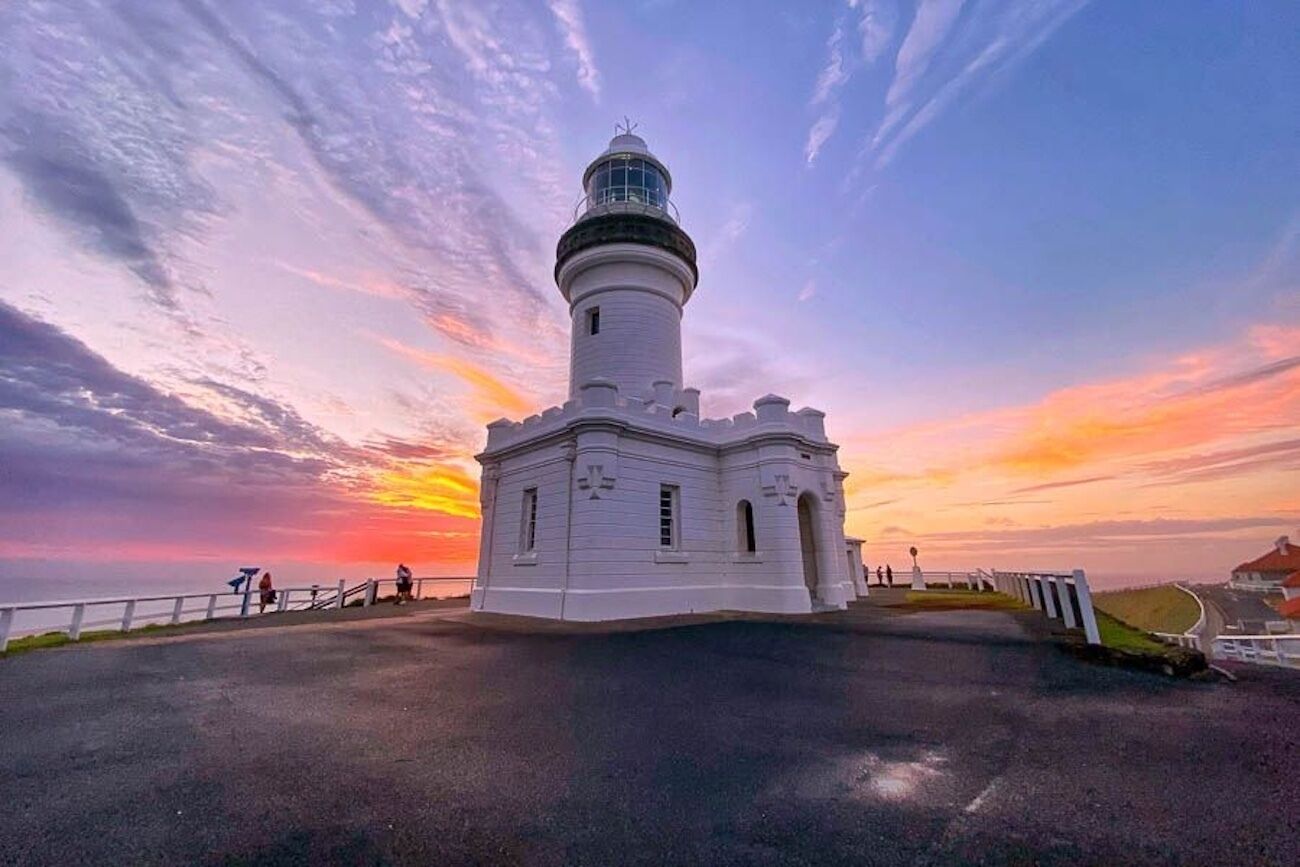 Un faro con exterior blanco, una parte superior redondeada y un pequeño balcón.