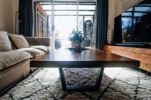 Ein modernes Wohnzimmer mit einer Couch, einem Couchtisch und einem Fernseher.