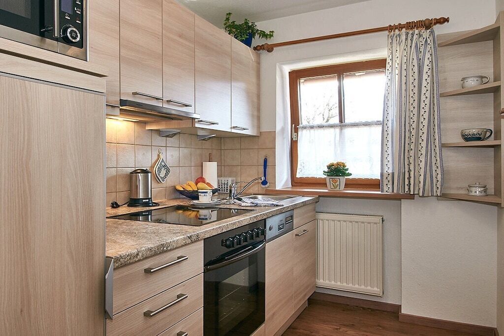 A compact kitchen with a built-in oven, a microwave, and a sink.