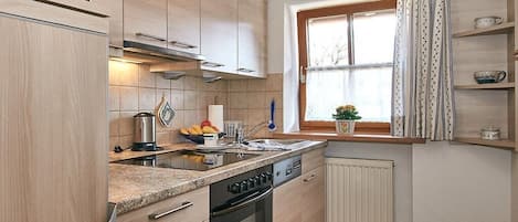 A compact kitchen with a built-in oven, a microwave, and a sink.