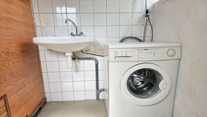 A laundry area with a washing machine and a sink. - OK40 Chalet Oostkapelle (Oostkapelle)