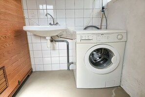 A laundry area with a washing machine and a sink. - OK40 Chalet Oostkapelle (Oostkapelle)