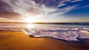 A beach with waves and a sunset. - OK40 Chalet Oostkapelle (Oostkapelle)