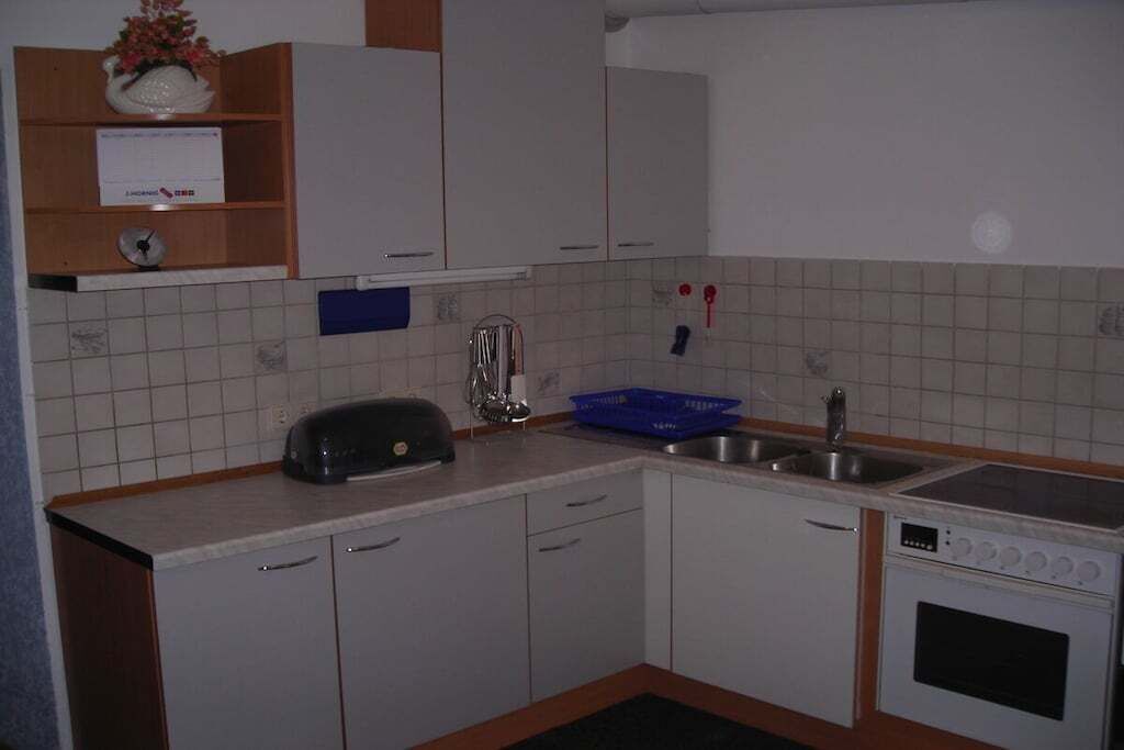 A kitchen with white cabinets, a toaster, a sink, and a stove.