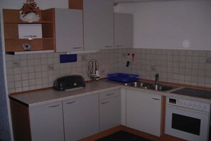 A kitchen with white cabinets, a toaster, a sink, and a stove. - Holiday apartment with 3 bedrooms (St. Stefan i \/R)