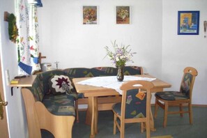A dining area with a table, chairs, a vase with flowers, and wall art. - Holiday apartment with 3 bedrooms (St. Stefan i \/R)