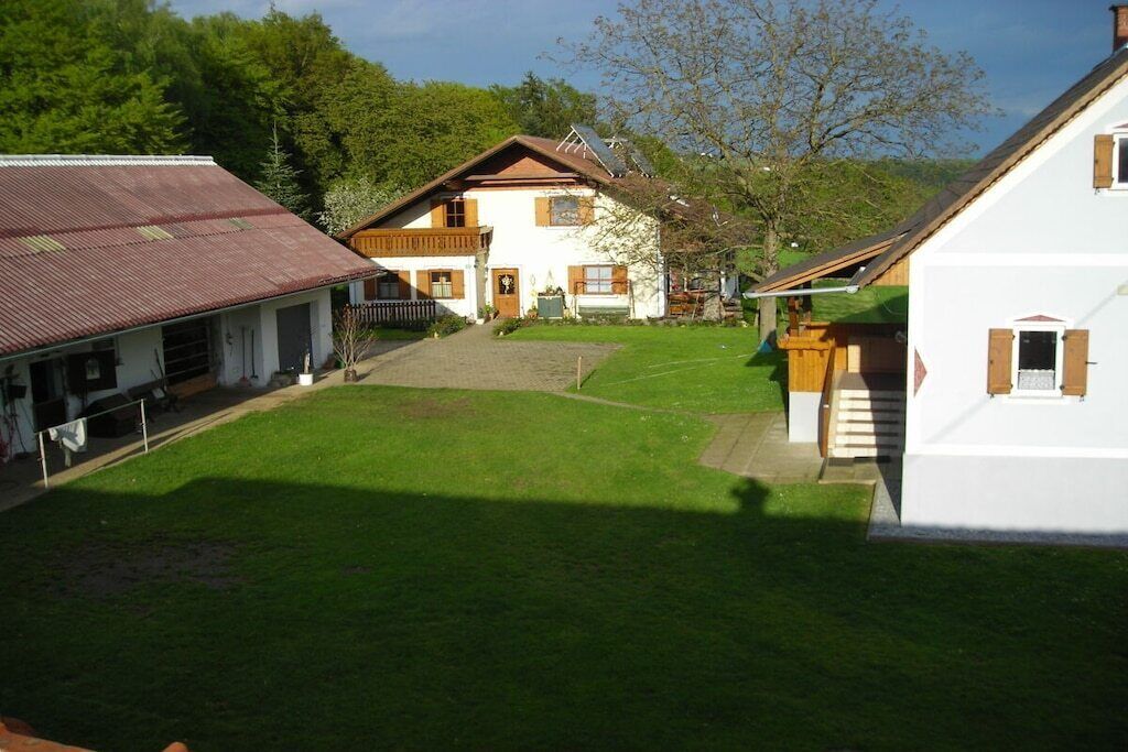 A residential area with two houses, a grassy yard, and a wooden fence.