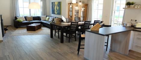 Un salon moderne comprenant un canapé, une table à manger et un coin cuisine.