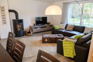 Ein Wohnzimmer mit einer Couch, einem Fernseher und einem Kamin.
