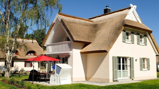 A house with a steeply pitched roof, a balcony, and a red umbrella. - Holiday home in Glowe with swimming pool (Glowe)