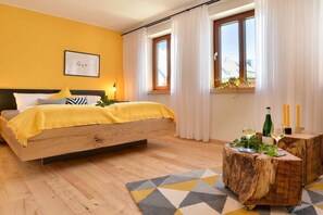A bedroom with a bed, a bedside table, a window with curtains, and a wall with a framed picture. - Klickerterhof "Young Beech" (Treis-Karden)