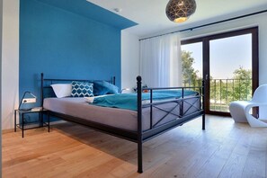 Un dormitorio moderno con cama, mesita de noche y vistas al exterior.