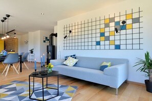 Un salon moderne avec un canapé, une table basse et un tapis à motifs géométriques.