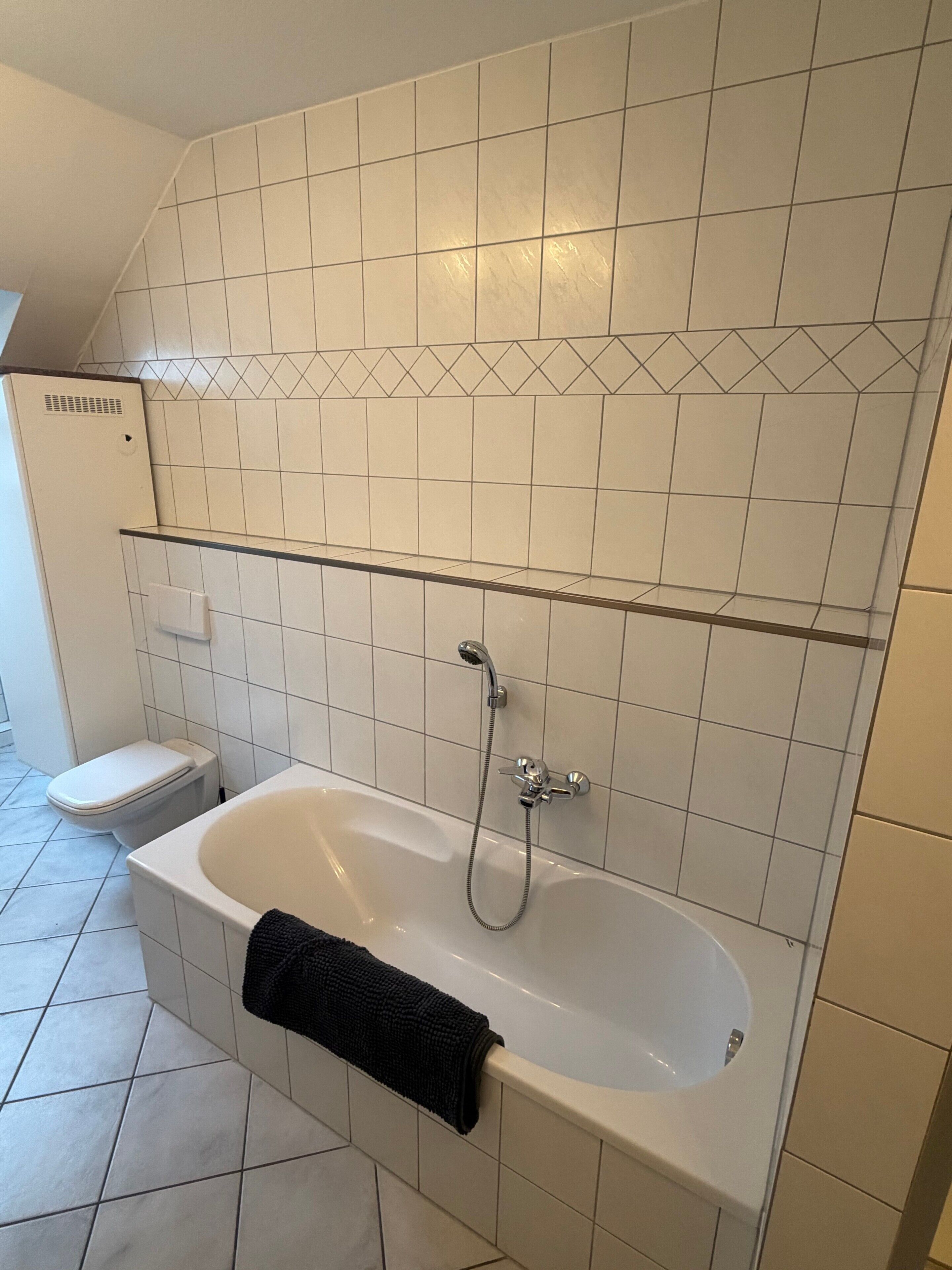 Ein Badezimmer mit Badewanne, Toilette und Dusche.