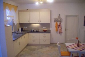 Eine Küche mit Spüle, Schränken und einem Tisch mit Stühlen.