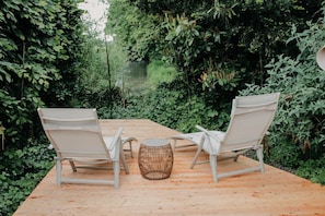 An outdoor seating area with two chairs and a round table, surrounded by dense greenery. - Olijf Room | Double Room with Private Bathroom | Near Utrecht (Maarssen)