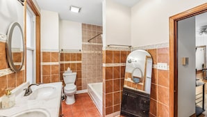 A bathroom with a toilet, sink, bathtub, and a vanity with a mirror. - Scott C.H. (Chicago)