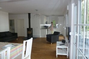 A modern living space with a kitchen, dining area, and a large window. - Holiday home in Arendsee with swimming pool (Arendsee)