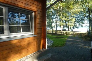 A wooden cabin with a window and a view of a forested area. - Holiday home in Arendsee with swimming pool (Arendsee)