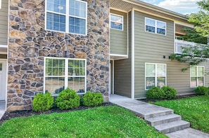 A two-story building with a stone facade and a green exterior.