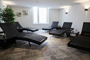 A modern lounge area with black lounge chairs and a patterned carpet. - Bernstein Suite & Breakfast Apartment 01 (Büsum)