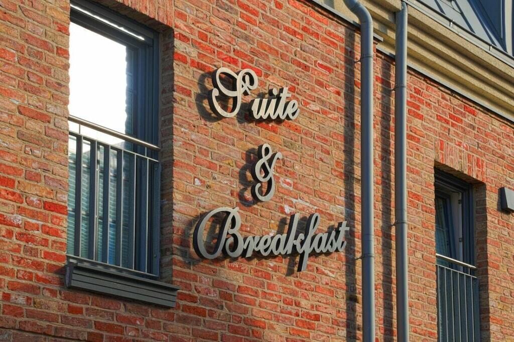 A brick building with a sign that reads 'Suite & Breakfast.'