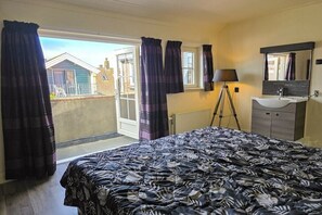 A bedroom with a bed, a window, a mirror, and a bathroom with a sink. - Holiday home in Domburg with swimming pool (Domburg)