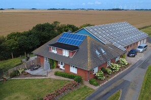 Une maison avec des panneaux solaires sur le toit et une terrasse.