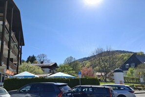 A parking area with cars, a blue parking sign, and buildings in the background. - Floor cutting suites "Wanderlust" (Tegernsee)