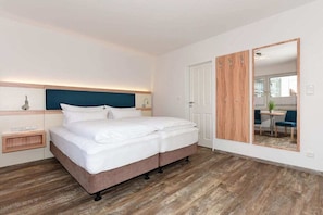 Ein Hotelzimmer mit einem Bett, einem Nachttisch und einem Spiegel.