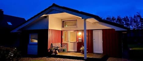 Una casa con un porche cubierto, una puerta y una ventana.